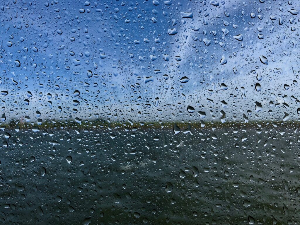 Serene Water Drops Wallpaper: Blurred Blue Sky & Landscape Background