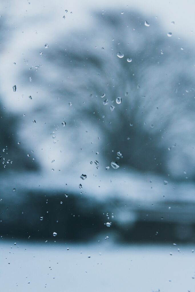 Serene Water Droplets Wallpaper on Glass with Blurred Nature Background