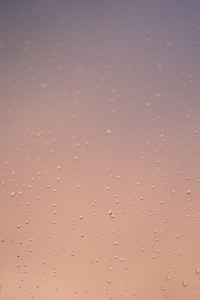 Serene Water Droplets on Glass: Warm Gradient Wallpaper Background