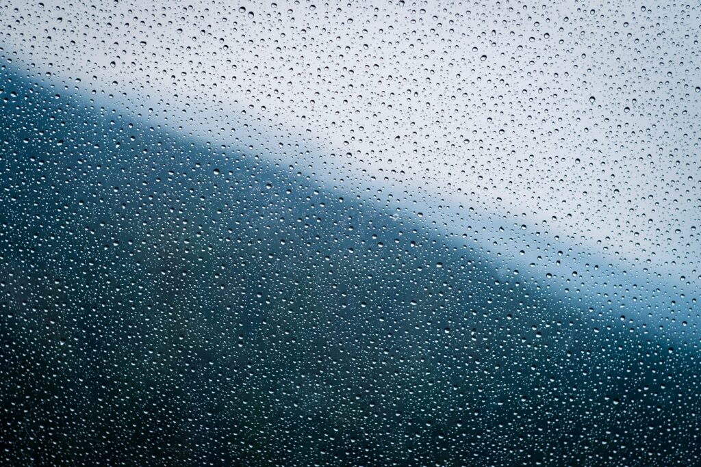 Serene Water Droplets on Glass: Captivating Textured Wallpaper