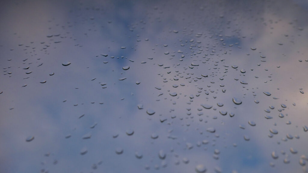 Serene Water Droplets on Glass - Soft Cloudy Sky Wallpaper
