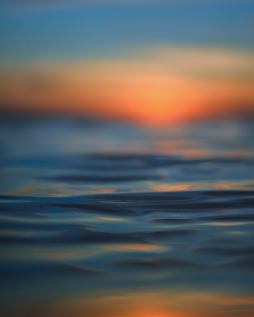 Serene Water Ripples Wallpaper with Colorful Sunset Background