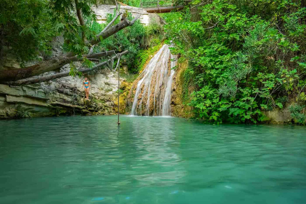 Serene Paphos Waterfall Wallpaper: Lush Greenery & Turquoise Pool