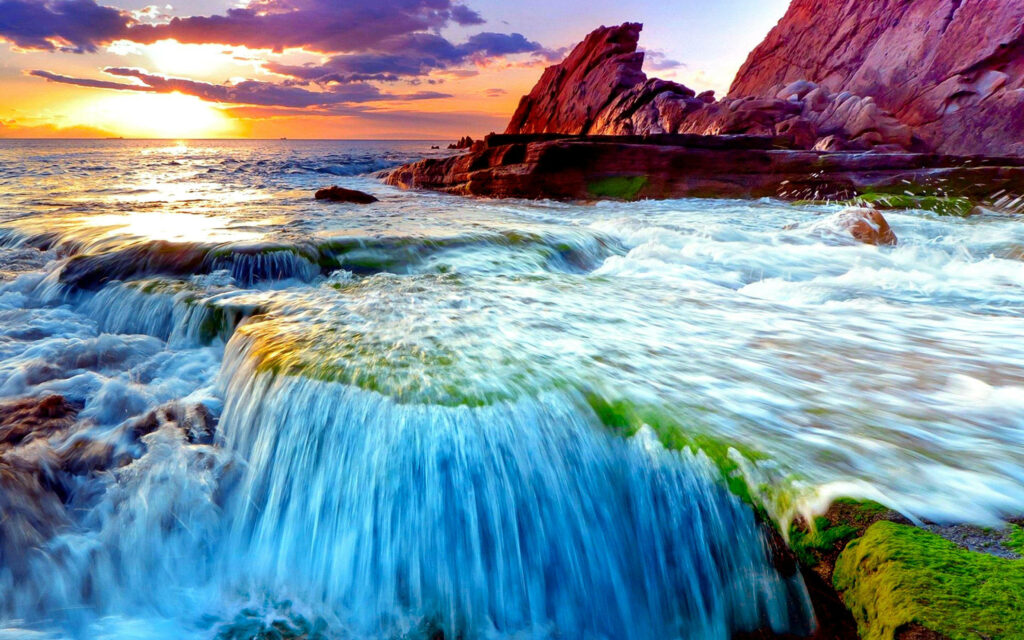 Tranquil Waterfall Wallpaper: Sunset Over Ocean & Mossy Rocks