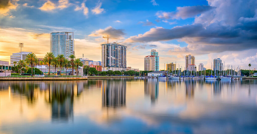 Scenic Waterfront Sunset: City Skyline, Palm Trees & Boats Wallpaper
