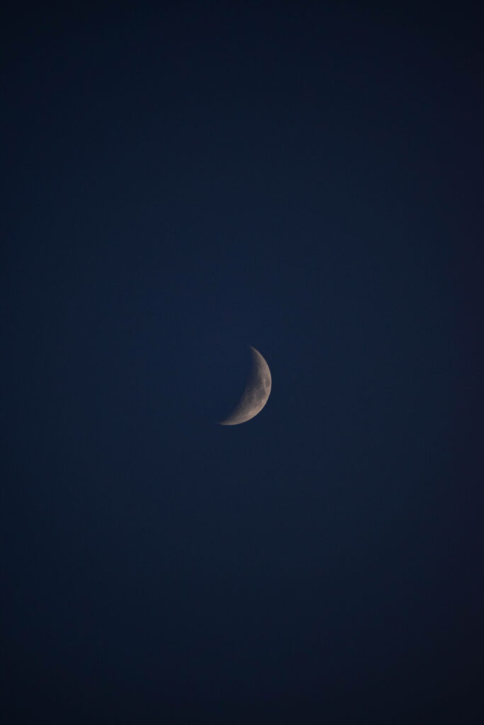 Serene Waxing Crescent Moon Wallpaper Against Dark Galaxy