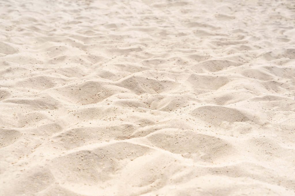 Realistic white sand beach wallpaper with textured ripples under natural sunlight serene background
