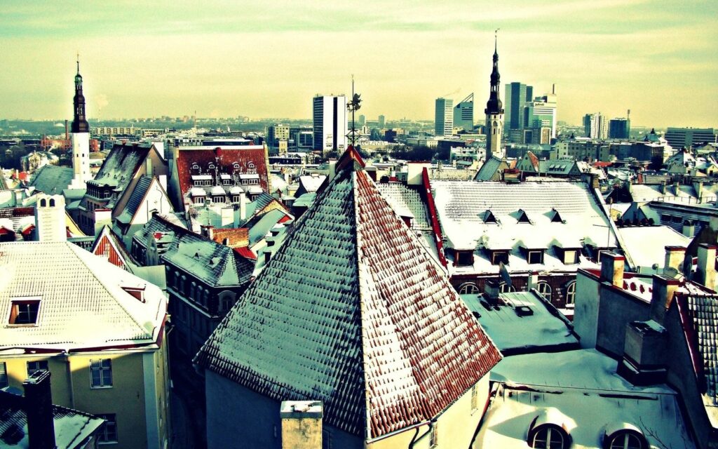 Serene Winter Cityscape: Snowy Rooftops & Towers Wallpaper