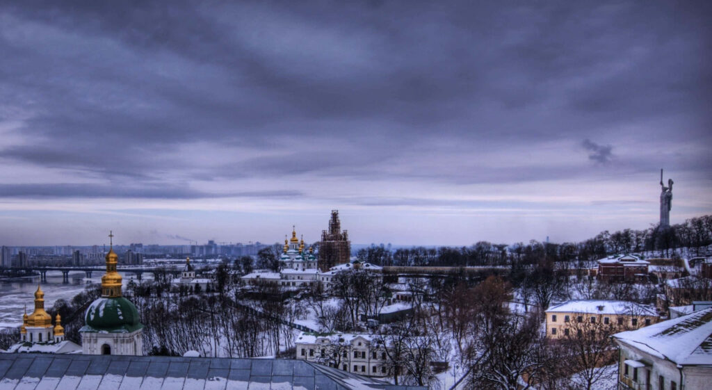 Serene Winter Cityscape Wallpaper: Snowy Rooftops & Golden Domes