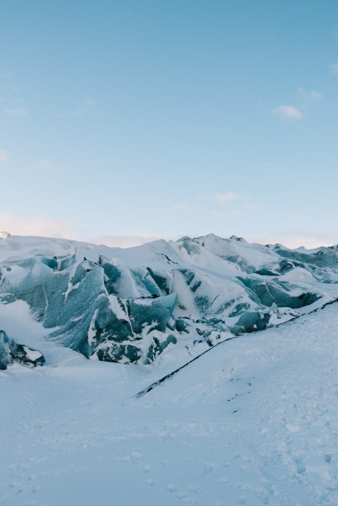 Serene winter landscape with ice-covered mountains snow-covered ground and clear blue sky Wallpaper