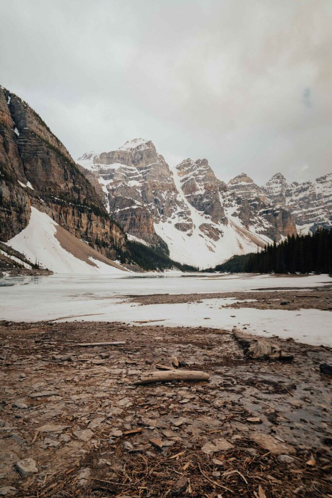 Serene winter landscape with rugged rocks snowy mountains and cloudy sky natural wallpaper background