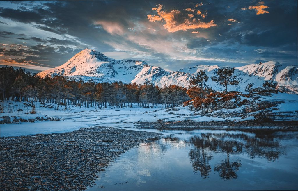 Winter mountain landscape reflection at sunset with snow-covered forest and calm lake wallpaper