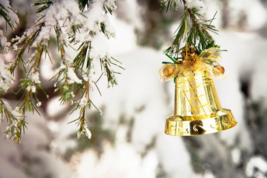 Festive Golden Bell on Snowy Pine: Serene Holiday Background Wallpaper