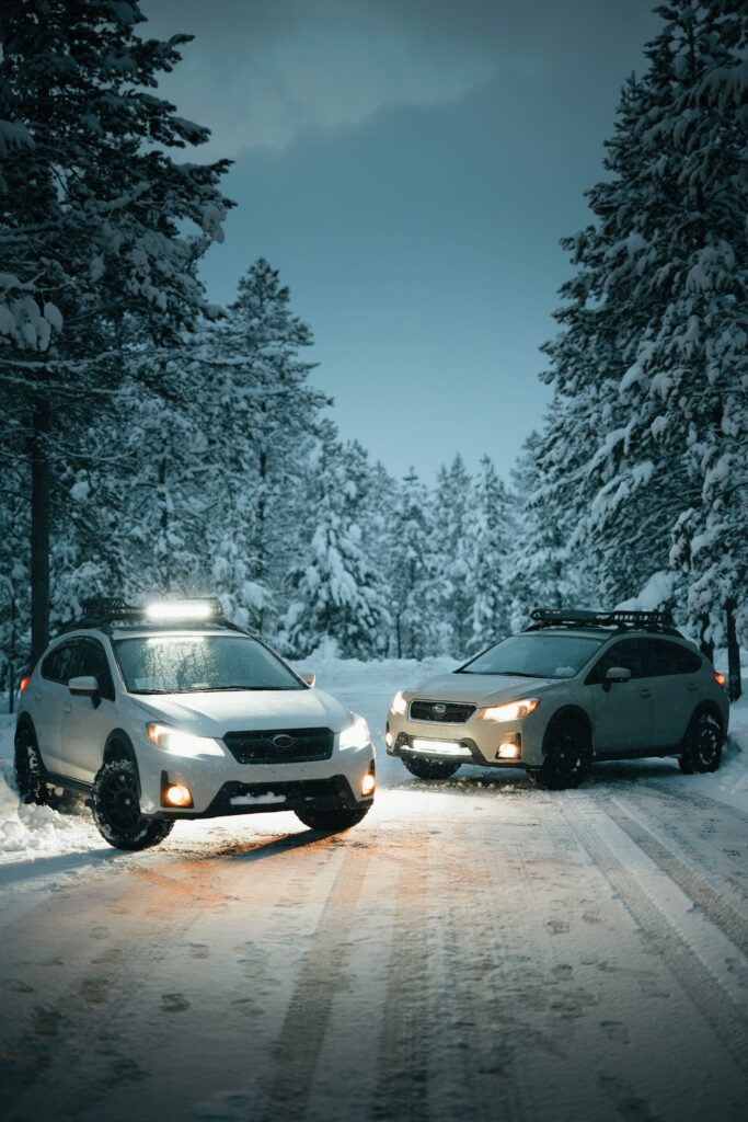 Serene Winter Wallpaper: Two White Cars on Snowy Road