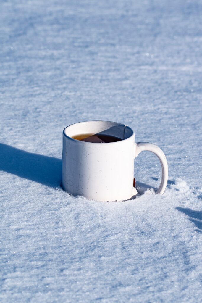 Warm Tea Mug on Snow: Serene Winter Scene Wallpaper Background