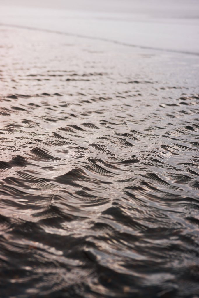 Close-up of gentle water ripples with soft light and dreamy blurred background minimal wallpaper