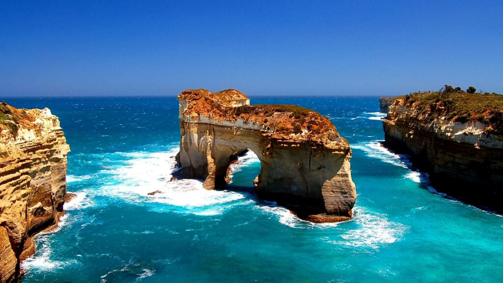 Serenity Amidst the Waves: HD Wallpaper showcasing a Majestic Natural Arch in the Sea
