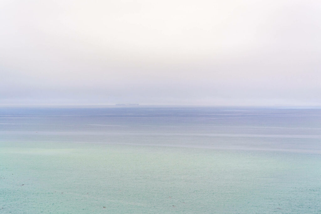 Serenity at Sea: A Tranquil Purple and Green Ocean Wallpaper