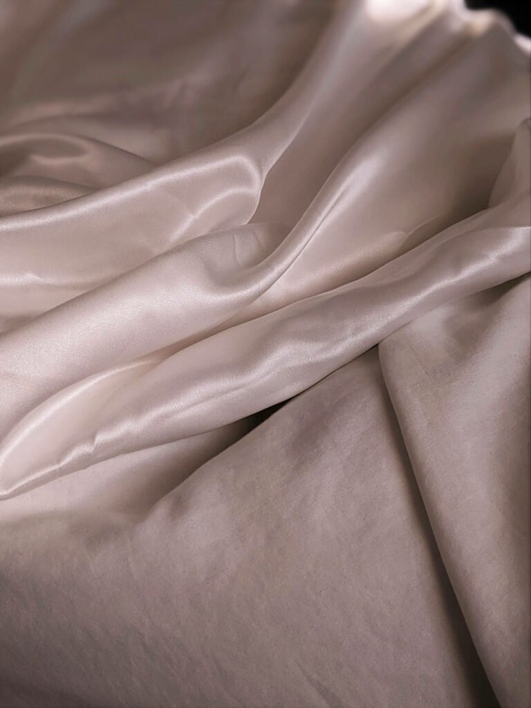 Subtle Elegance: Captivating Champagne-colored Silk Under Soft Ambient Lighting Wallpaper