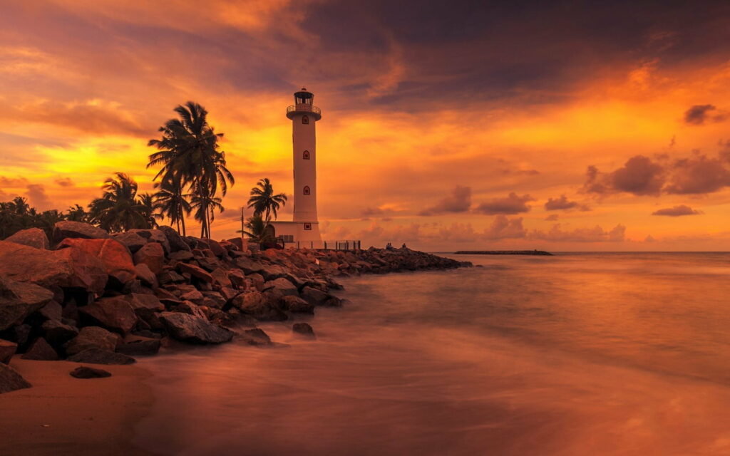 Romantic Coastal Serenity: Majestic Lighthouse Embraces Tropical Tranquility in Sri Lanka's Golden Sunset Wallpaper