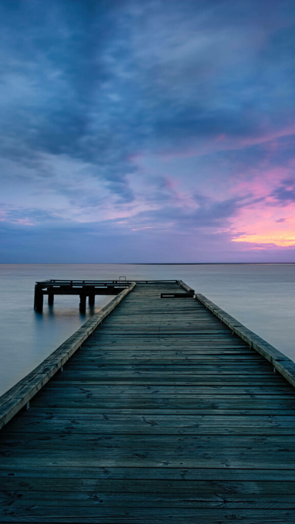 Tranquil Sunset Reflections: Serene Wooden Pier in a 4k Ultra iPhone Wallpaper