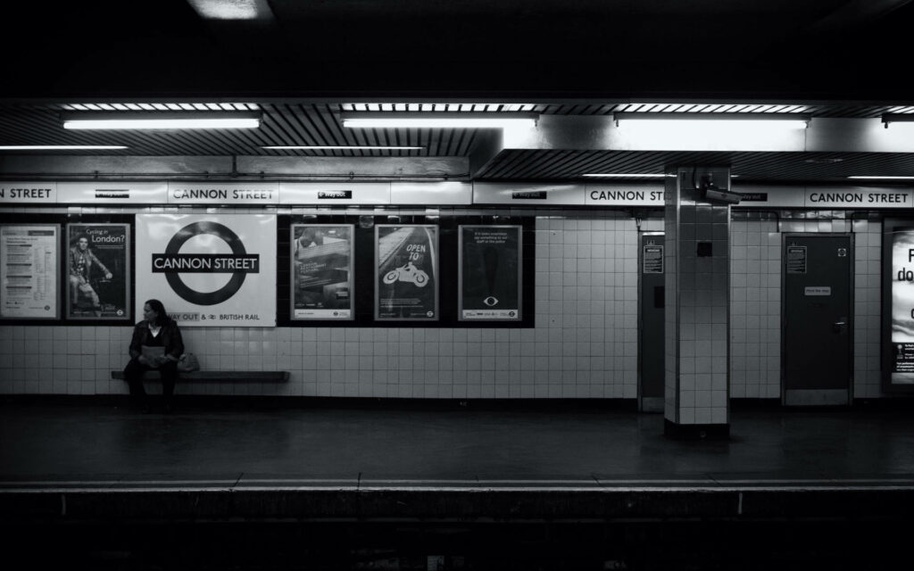 Solitude in Monochrome: A Captivating Portrait of a Lone Woman in an Empty Subway Station Wallpaper