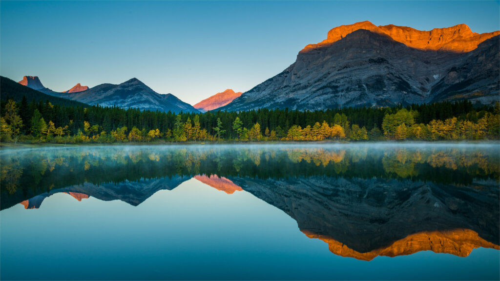 Sunset Splendor: Mesmerizing Mountain Layers and Reflecting Trees Wallpaper