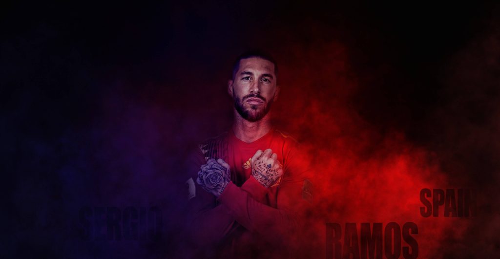 Sergio Ramos football wallpaper with intense crossed arms pose and red blue smoke background