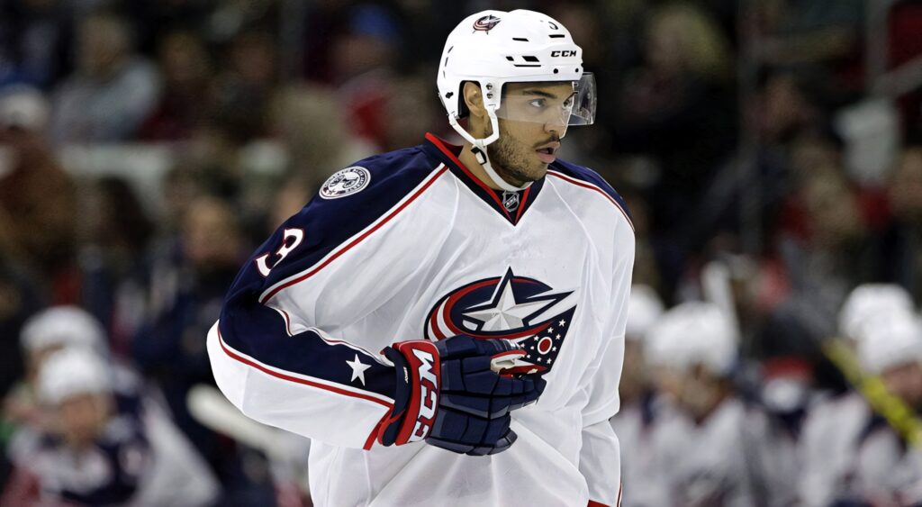 Seth Jones in Columbus Blue Jackets jersey showing intensity and focus on ice in stadium background Wallpaper