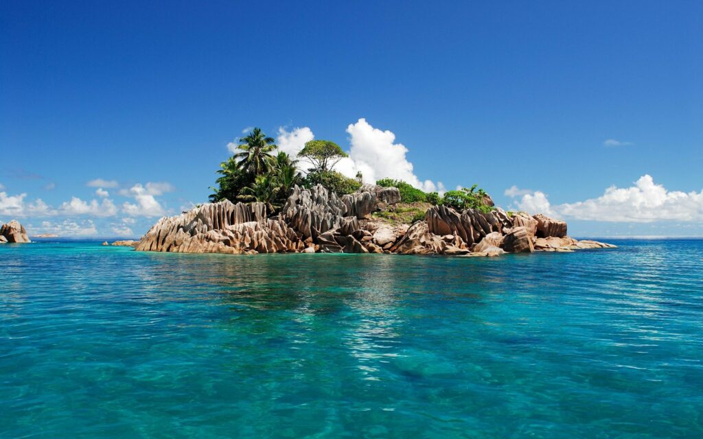 Tropical Seychelles island with granite rocks turquoise waters lush greenery bright blue sky wallpaper