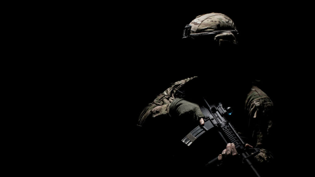 The Enigmatic Guardian: A Foreboding Military Figure Embracing the Shadows Wallpaper