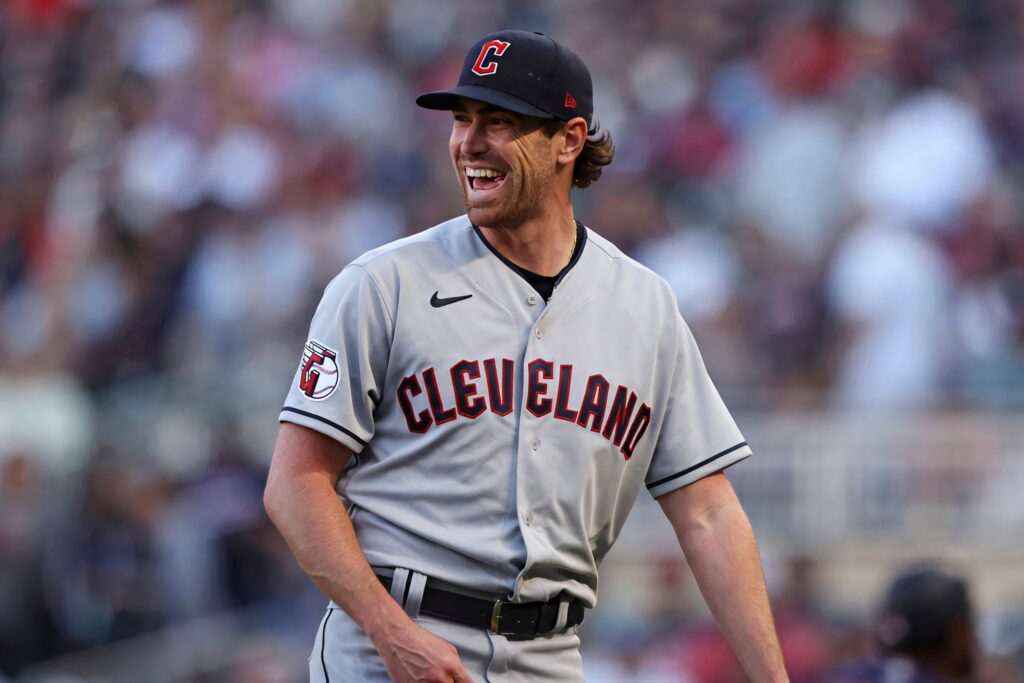 Cleveland Guardians pitcher Shane Bieber in gray away uniform pitching on vibrant stadium mound Wallpaper