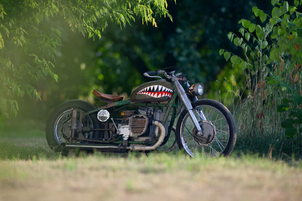 Shark Tooth Bobber Wallpaper: Retro Custom Motorcycle in Green Nature