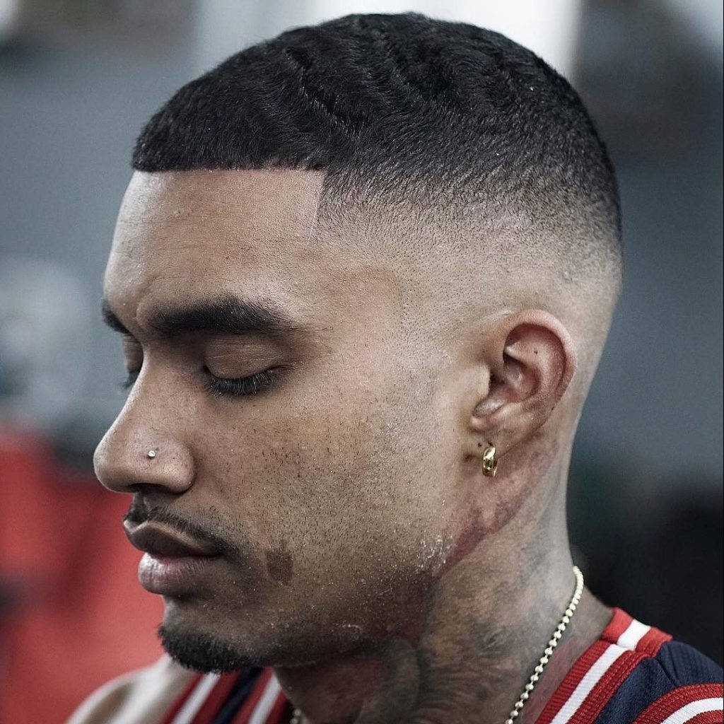 Sharp bald fade mens hairstyle with textured wavy hair and nose stud in sports jersey wallpaper