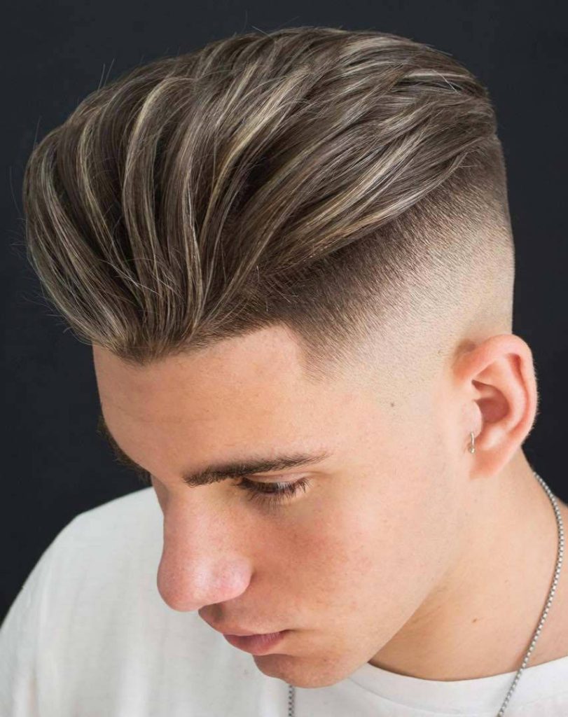Sharp disconnected pompadour men haircut with blonde highlights and silver chain studio portrait wallpaper