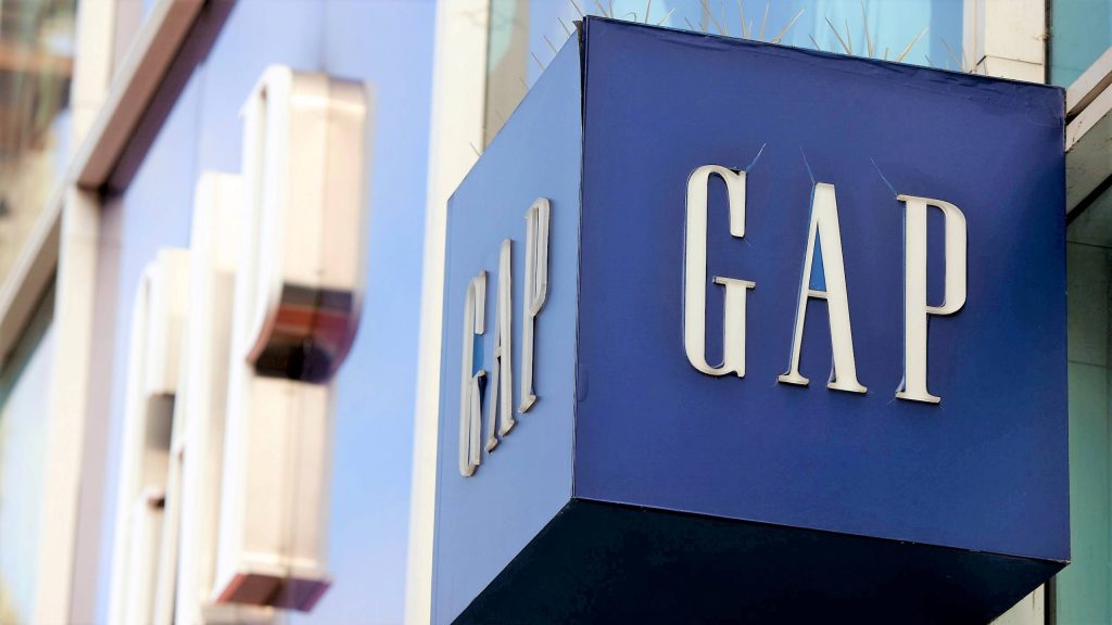 Sharp Gap store blue cube sign with white logo blurred background modern retail wallpaper