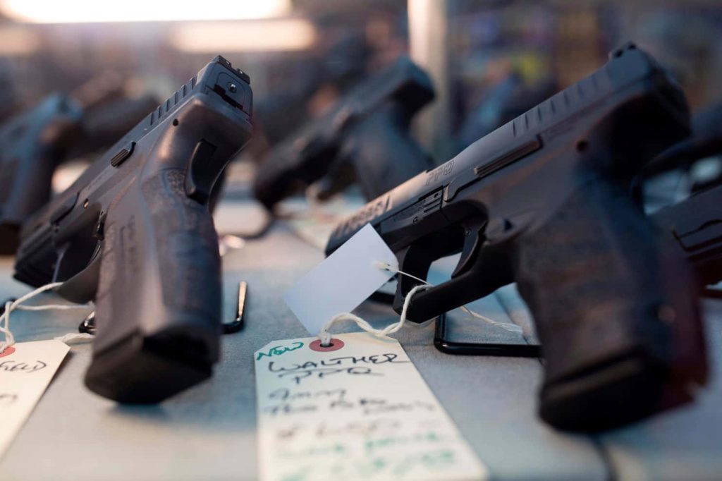 Close-up Walther PPQ 9mm pistols with price tags on a sharp gun wallpaper background