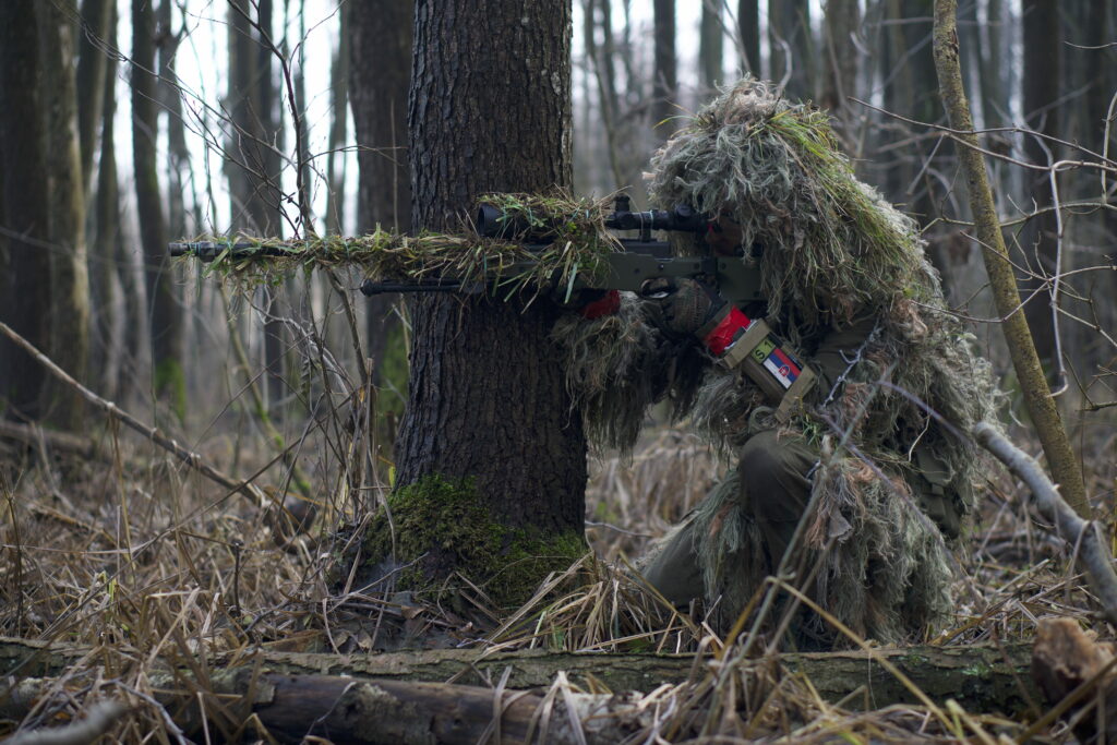 Hunter in Action with a Powerful Green Rifle: High-Resolution 5K Wallpaper