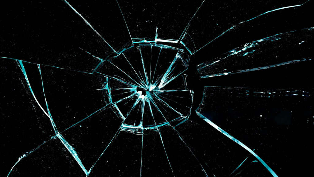 Shattered computer lock screen wallpaper with realistic cracked screen effect on black background