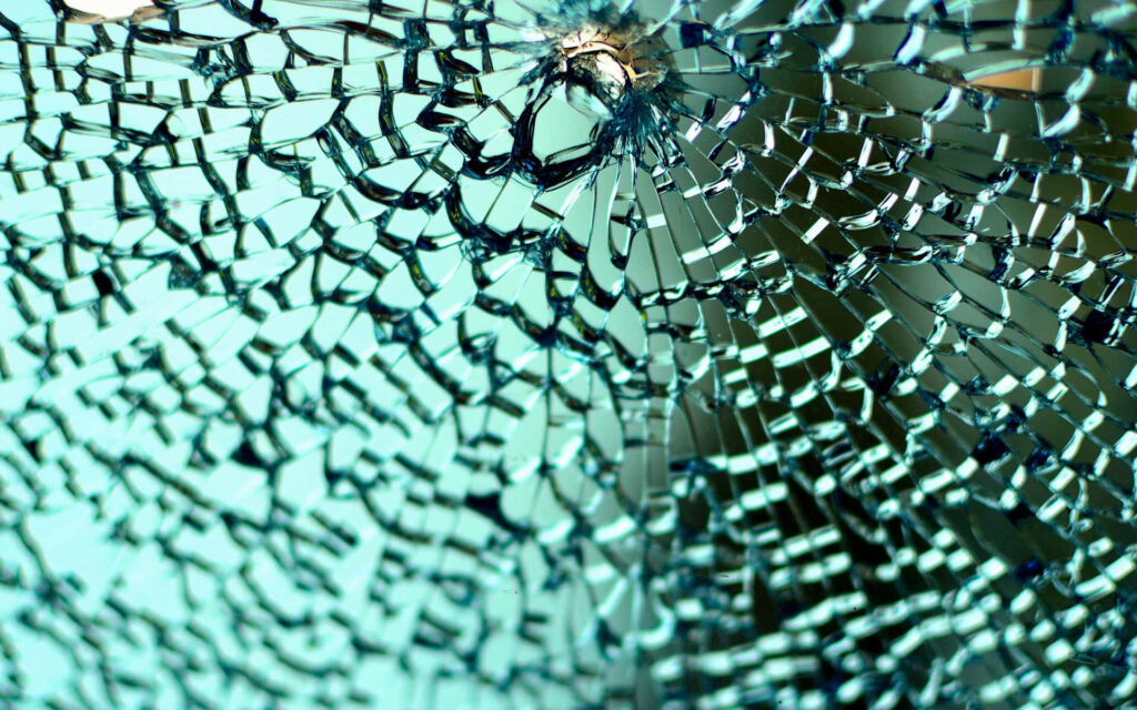 Close-up shattered glass wallpaper with intricate cracks and blue green tones for modern backgrounds