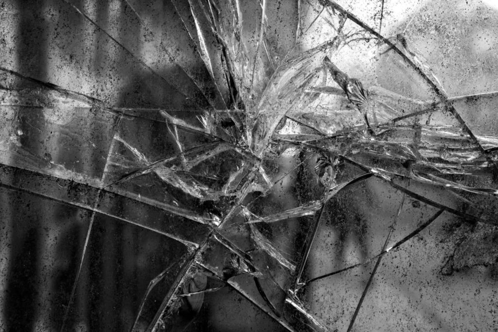 Shattered glass explosion abstract texture with sharp fragments in high contrast grayscale background Wallpaper