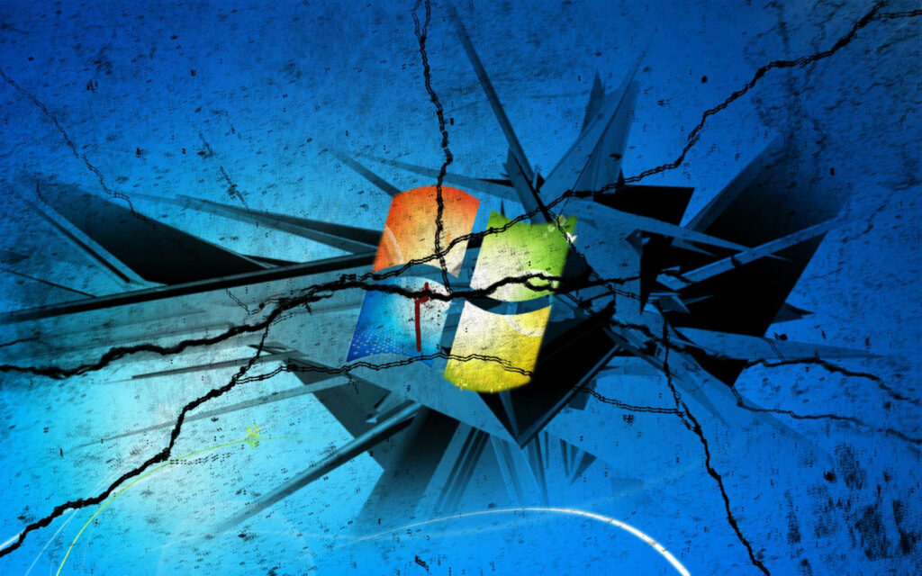 Fractured Technology: A Surreal Wallpaper of Cracked Computer Screen and Windows Desktop