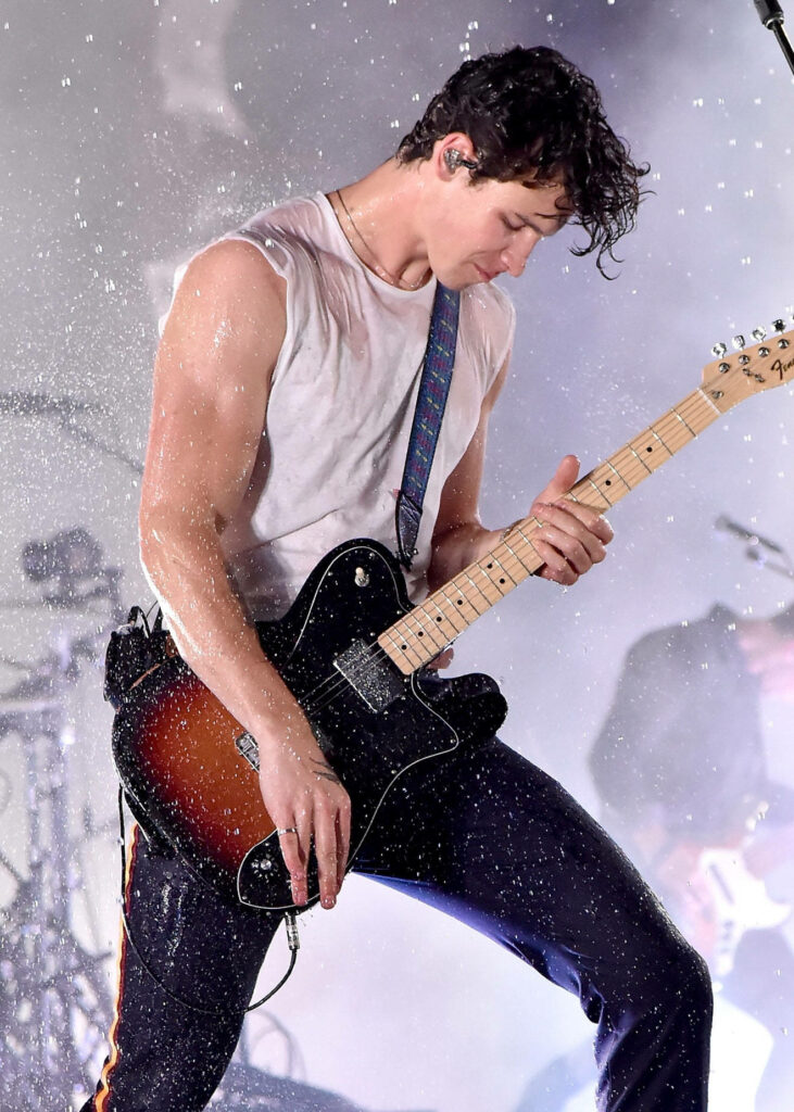 Shawn Mendes performing live at VMAs 2018 playing guitar with dramatic water effects background Wallpaper