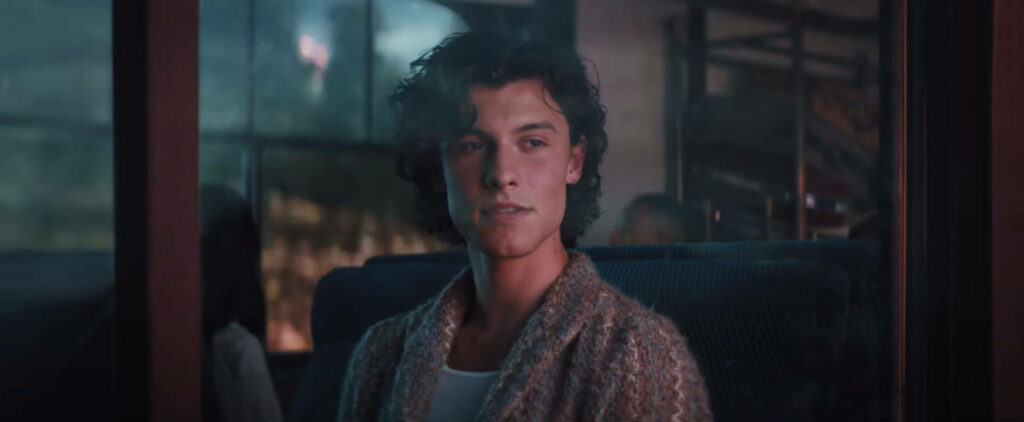 Shawn Mendes sitting by train window reflecting calm introspective moment In Wonder video Wallpaper