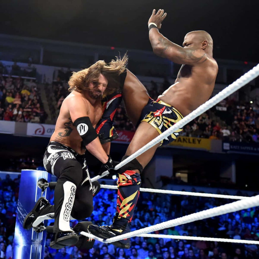 Shelton Benjamin kicks AJ Styles in intense WWE match with vibrant packed arena background wallpaper