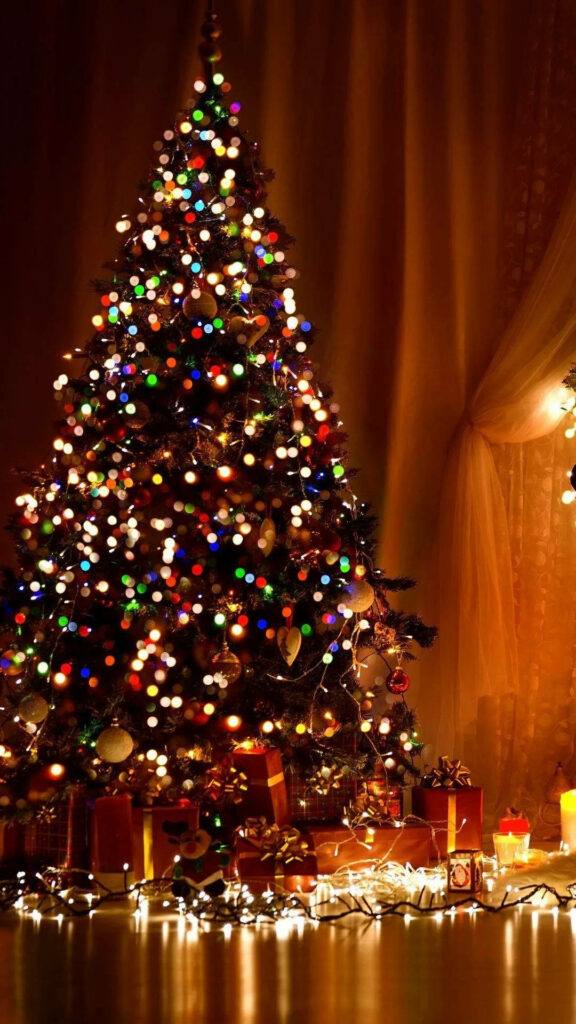 Cozy Christmas tree wallpaper with colorful lights and wrapped gifts for festive phone background