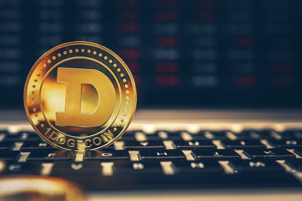 Golden Dogecoin upright on keyboard highlighting digital cryptocurrency tech and finance theme Wallpaper