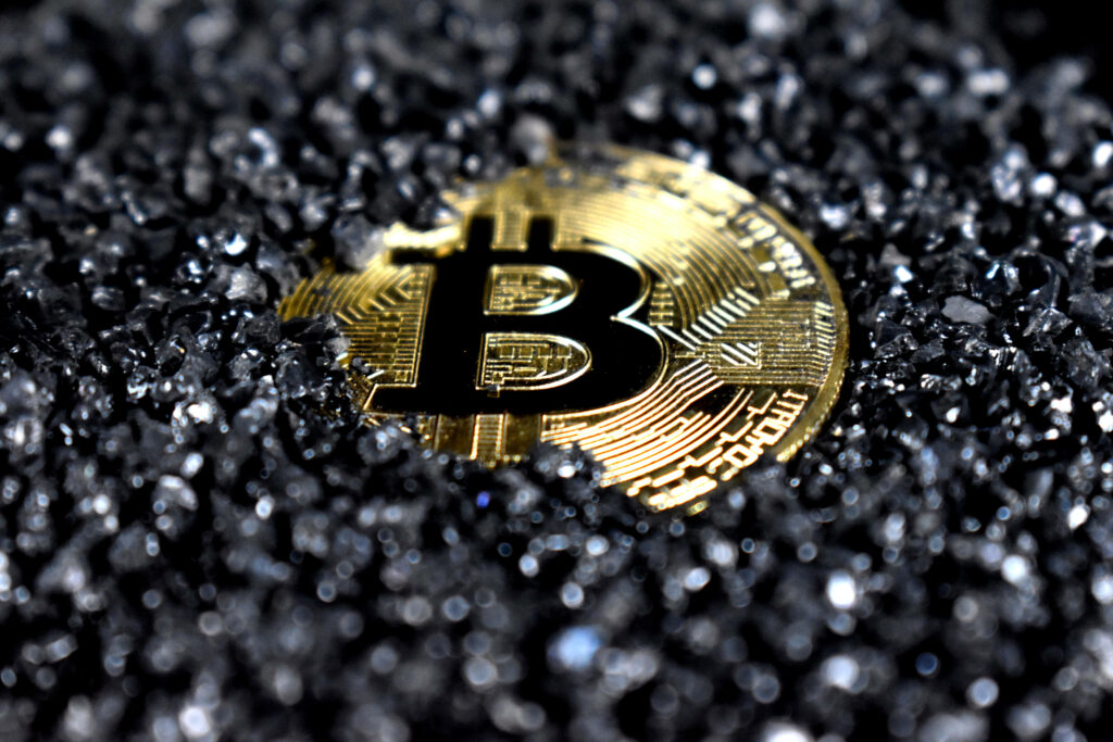 Shiny Bitcoin token rising from black crystals symbolizing cryptocurrency future wallpaper