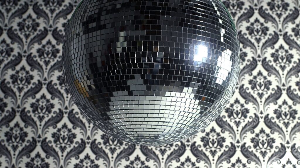 Elegant disco ball reflecting light on black and white damask wallpaper creating retro vibe