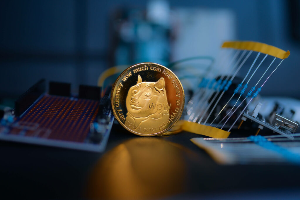 Shiny Dogecoin coin in dim tech room with blurred circuit boards symbolizing digital innovation Wallpaper